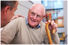 Senior man sitting in a wheelchair with sunlit window behind him